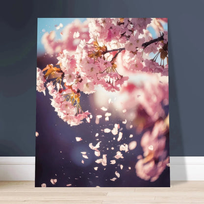 Dreamy pink and white cherry blossom branches with delicate petals falling against a soft, pale blue spring sky.
