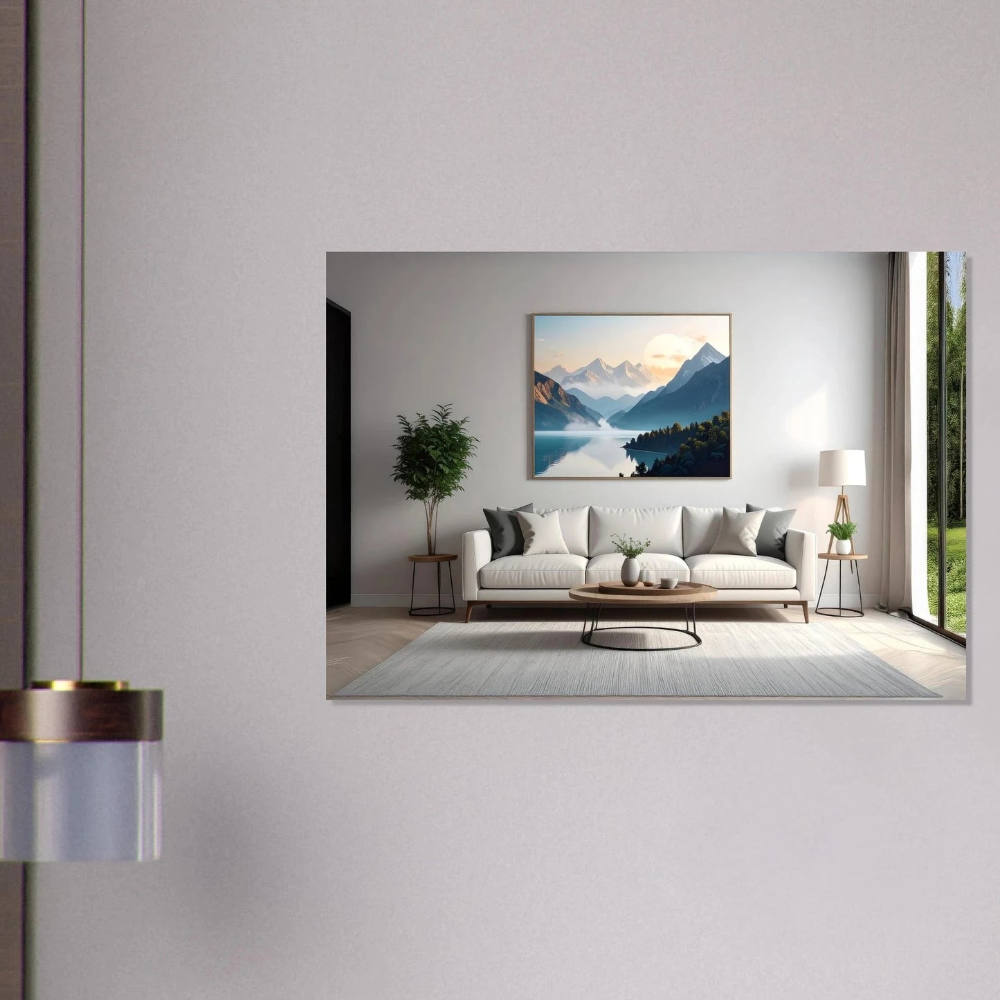 Large horizontal wall art of blue misty mountains and a lake over a white modern sofa in a bright living room.